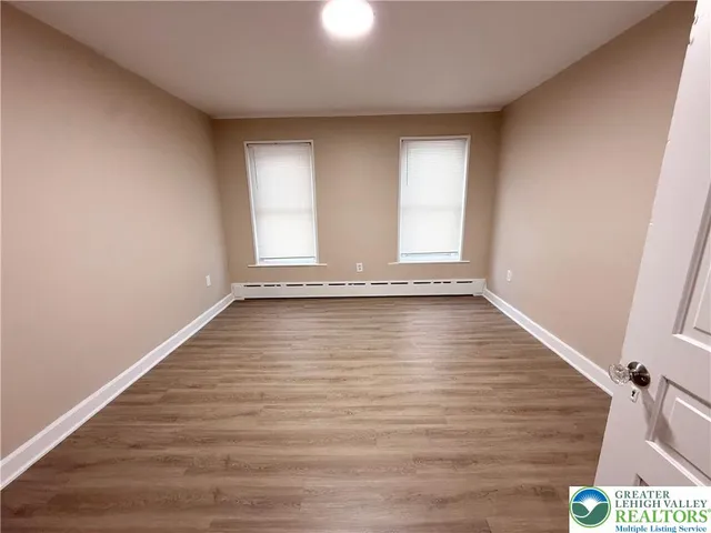 a view of empty room with wooden floor
