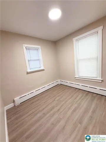 a view of an empty room with wooden floor