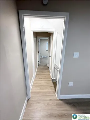 a view of a hallway with wooden floor and staircase