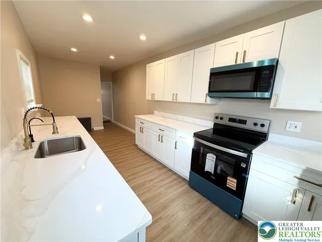 a kitchen with stainless steel appliances a stove a sink and a microwave