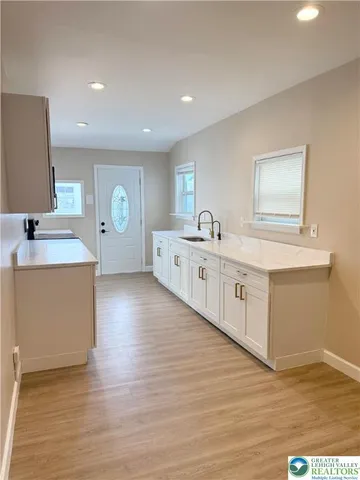 a living room with stainless steel appliances furniture or kitchen view and wooden floor