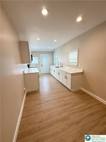 a kitchen with stainless steel appliances white cabinets a sink a stove a refrigerator and a microwave