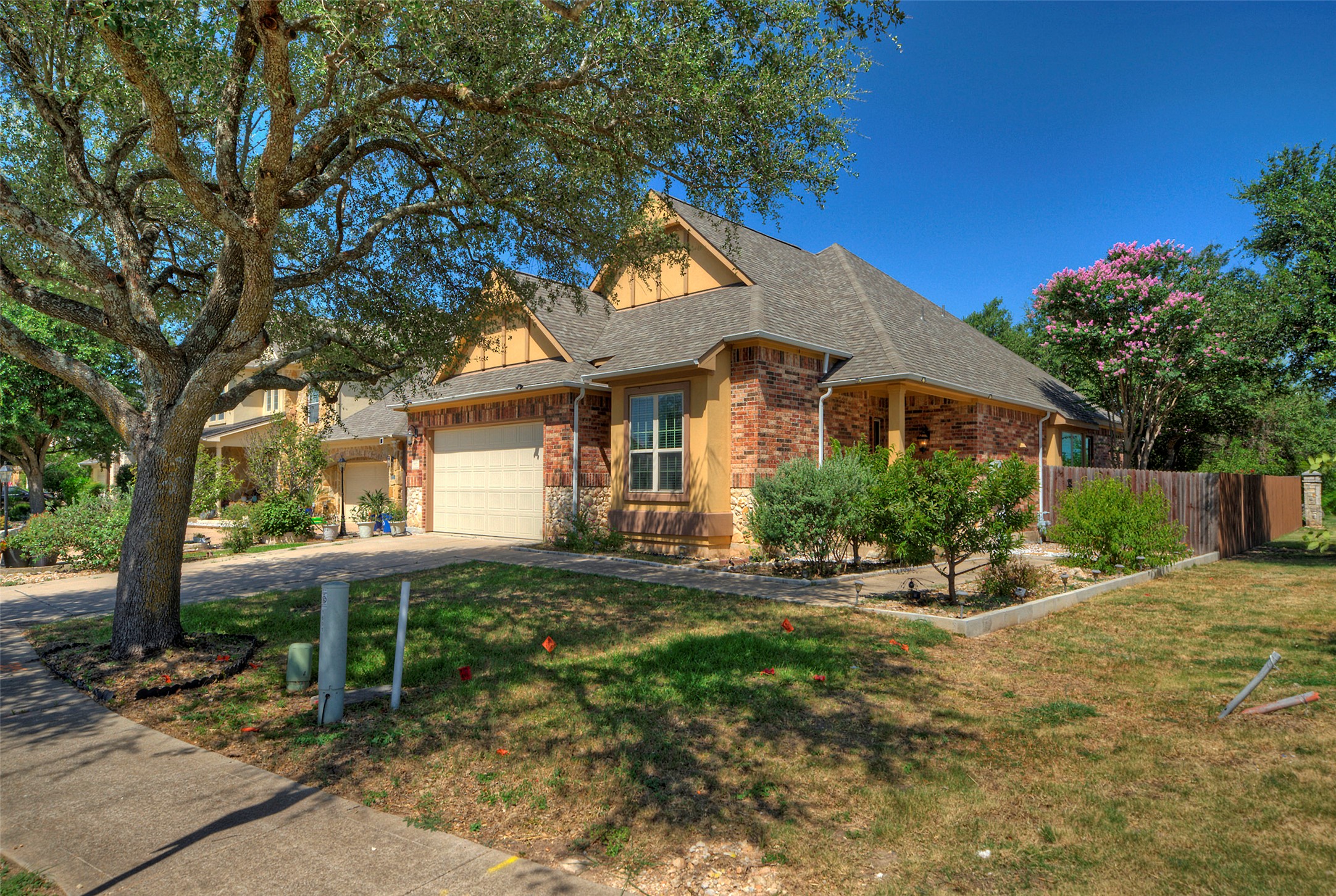 1601 Nelson Ranch Loop Cedar Park, TX 78613 - Photo 3 of 30 An inviting brick and stucco facade rises behind established shade trees and structured garden beds.