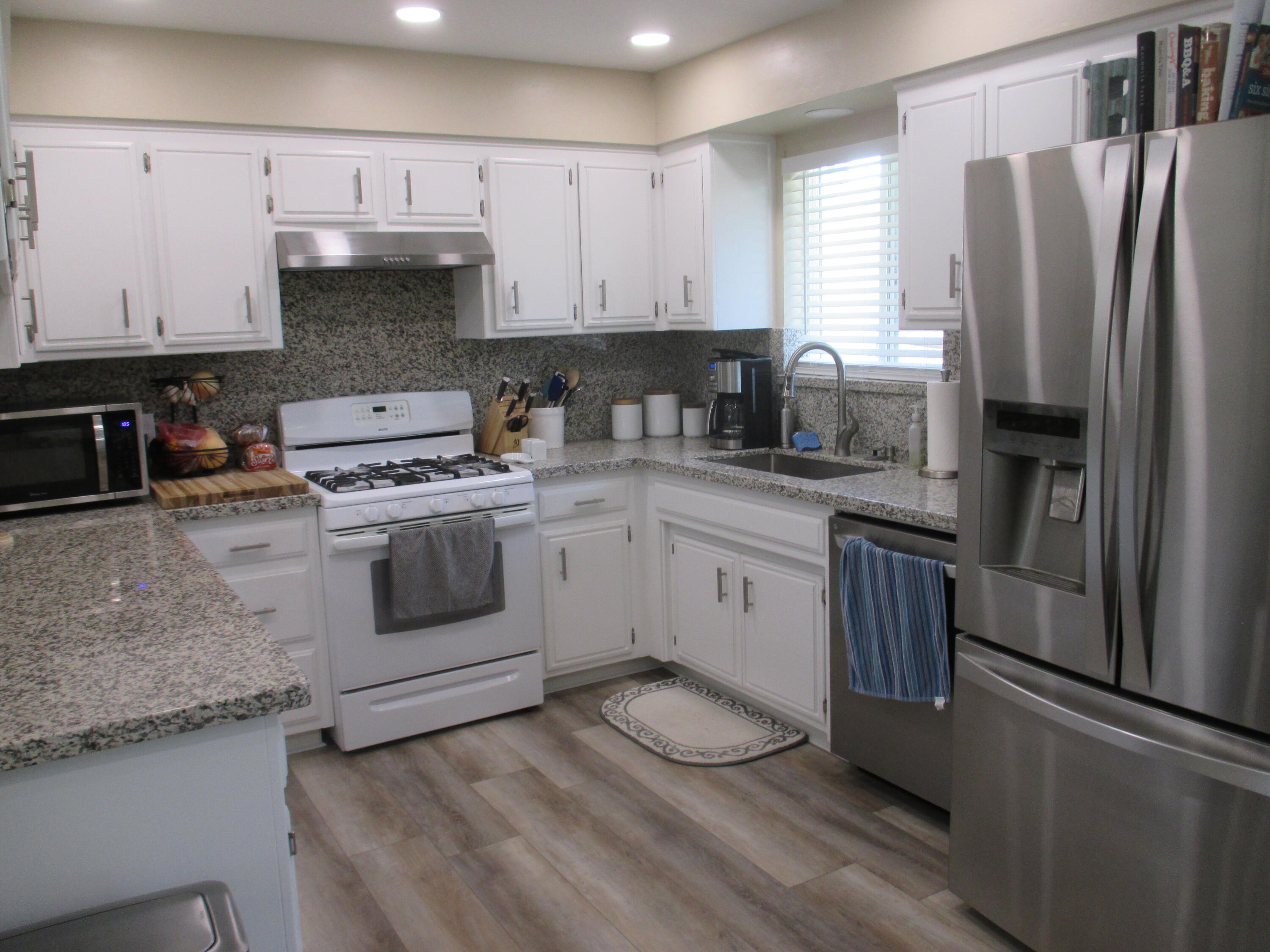 21908 Mariposa Road Tehachapi, CA 93561 - Photo 5 of 23 a kitchen with a white cabinets and white appliances