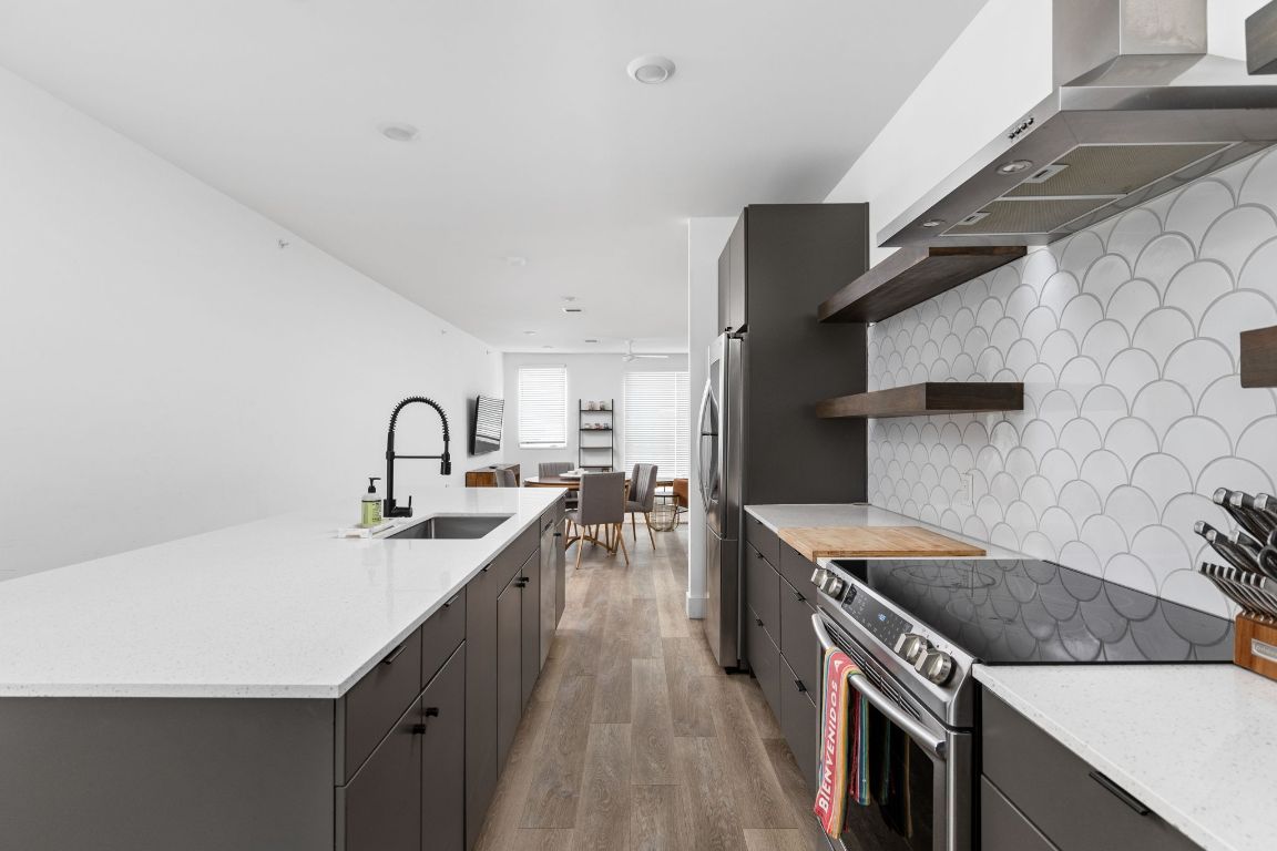 2709 East 5th Street, Unit 1306 Austin, TX 78702 - Photo 2 of 26 Sleek quartz countertops, stainless steel appliances, and custom backsplash.
