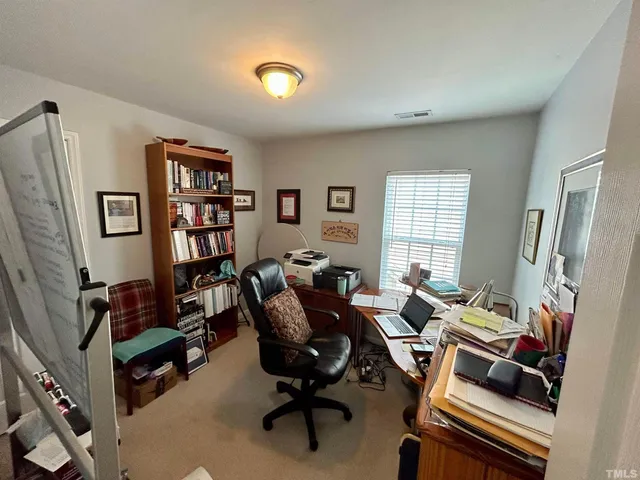a view of a livingroom with workspace and a window