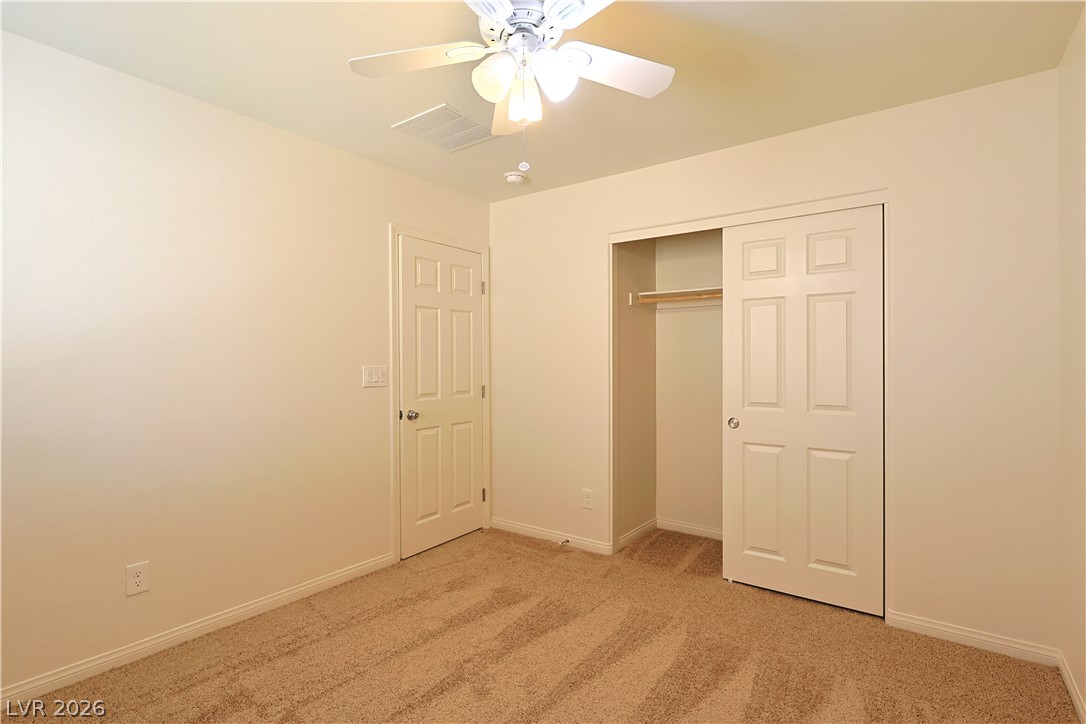 8663 Reynolds Spring Street Las Vegas, NV 89178 - Photo 24 of 32 Soft carpeting pairs with neutral walls in this comfortable bedroom featuring a sliding closet door.