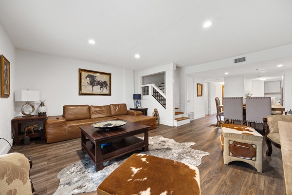 a living room with furniture and a wooden floor