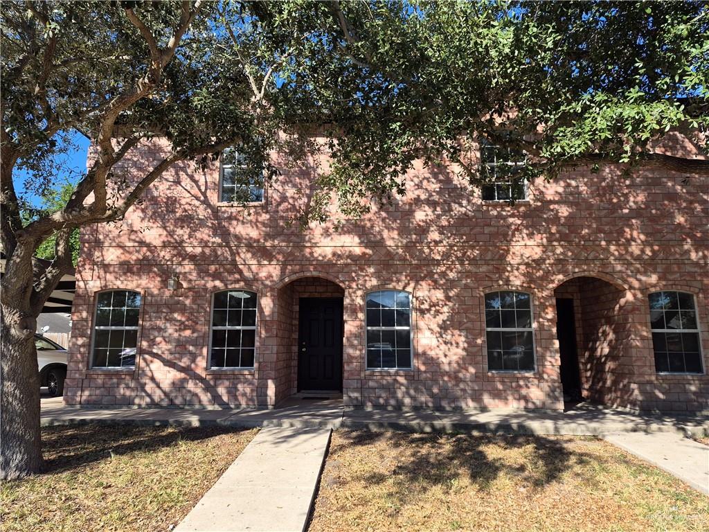 a front view of a house with a tree