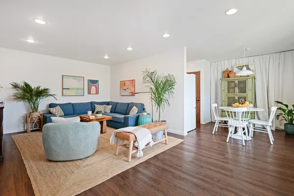 a living room with furniture wooden floor and a potted plant