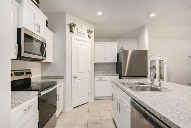 a kitchen with stainless steel appliances granite countertop a refrigerator sink and stove