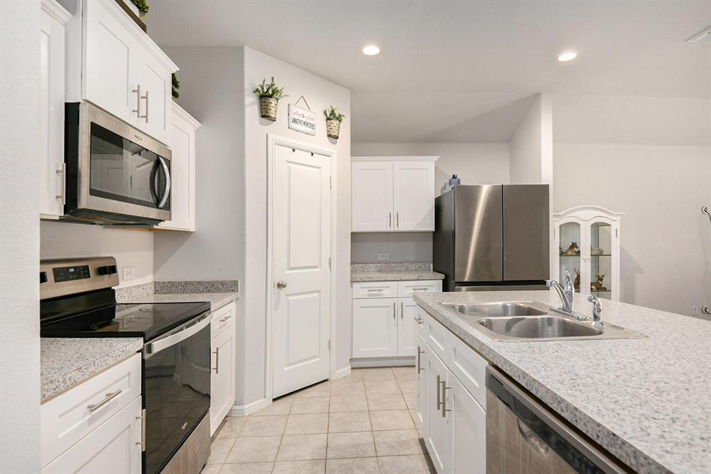 805 Durango Lane Cleburne, TX 76033 - Photo 6 of 23 a kitchen with stainless steel appliances granite countertop a refrigerator sink and stove