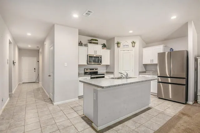a kitchen with stainless steel appliances granite countertop a refrigerator a sink and a stove