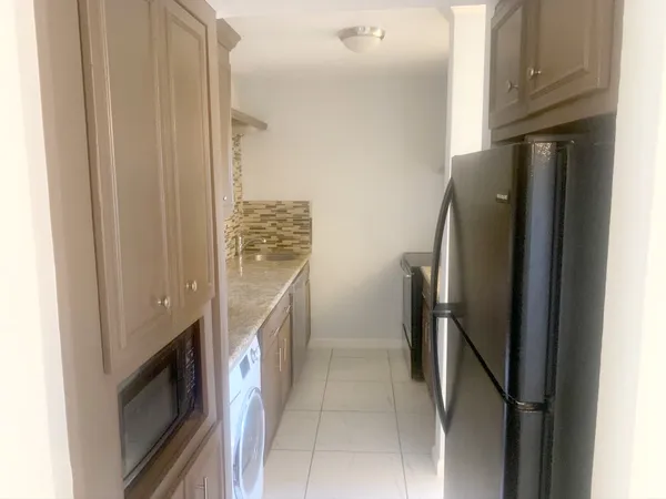 a kitchen with stainless steel appliances granite countertop a refrigerator and a sink