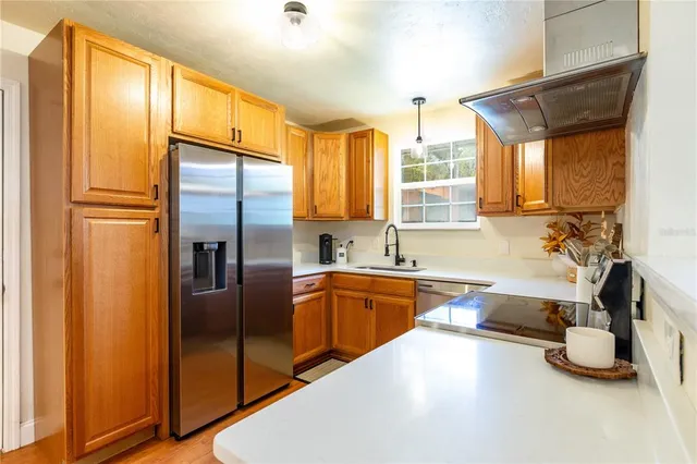 a large kitchen with kitchen island a large window and stainless steel appliances