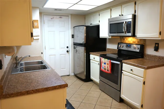 a kitchen with stainless steel appliances granite countertop a stove a refrigerator and a microwave