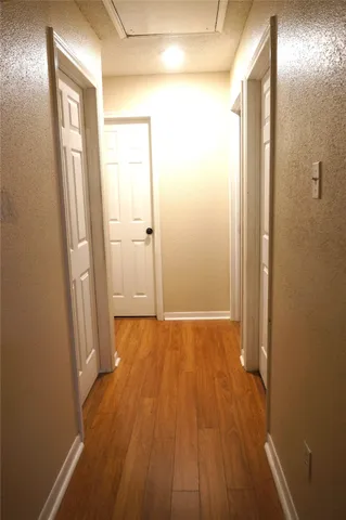 a view of a hallway with wooden floor