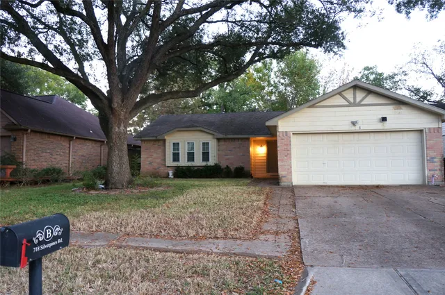 a view of a house with a yard and large tree