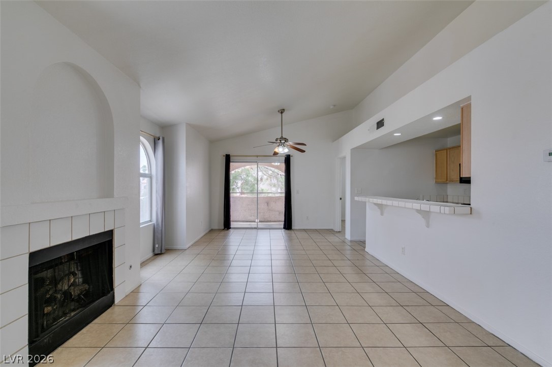 7570 West Flamingo Road, Unit 252 Las Vegas, NV 89147 - Photo 12 of 44 A fireplace feature in a living area with tiled floors and an open concept.