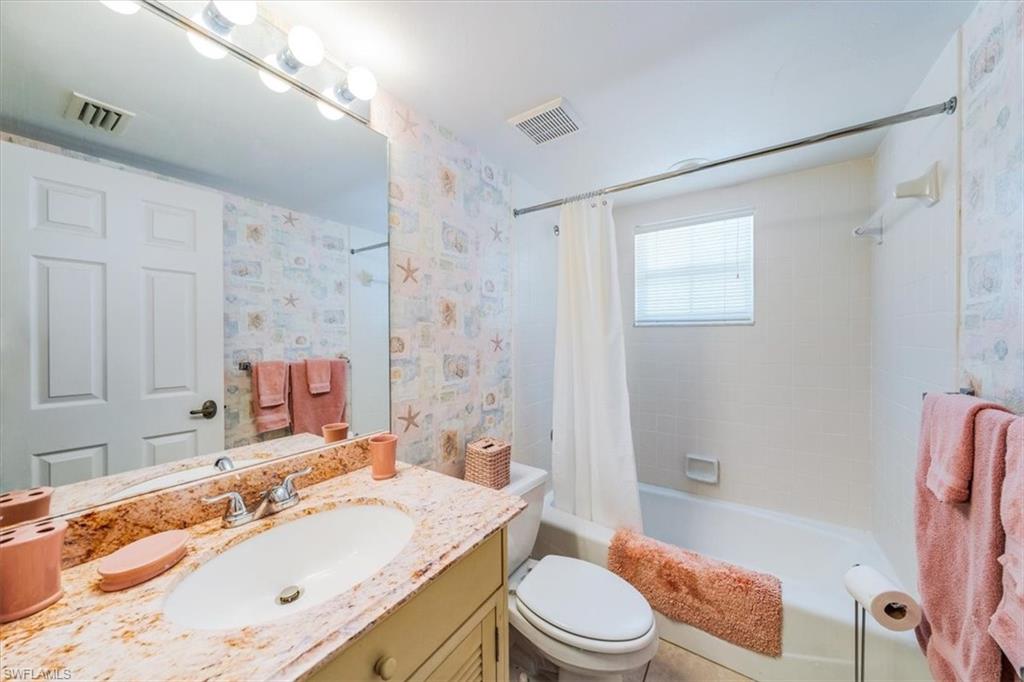 5637 Turtle Bay Drive, Unit 16 Naples, FL 34108 - Photo 15 of 22 a bathroom with a granite countertop sink toilet tub and shower