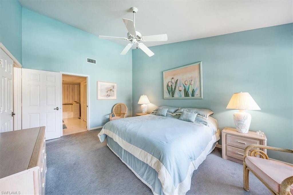 5637 Turtle Bay Drive, Unit 16 Naples, FL 34108 - Photo 17 of 22 a bedroom with a bed and a chandelier