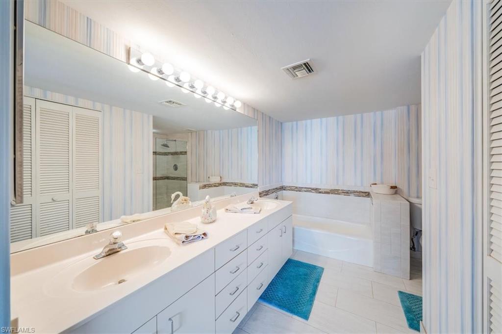 5637 Turtle Bay Drive, Unit 16 Naples, FL 34108 - Photo 18 of 22 a spacious bathroom with a double vanity sink and a mirror