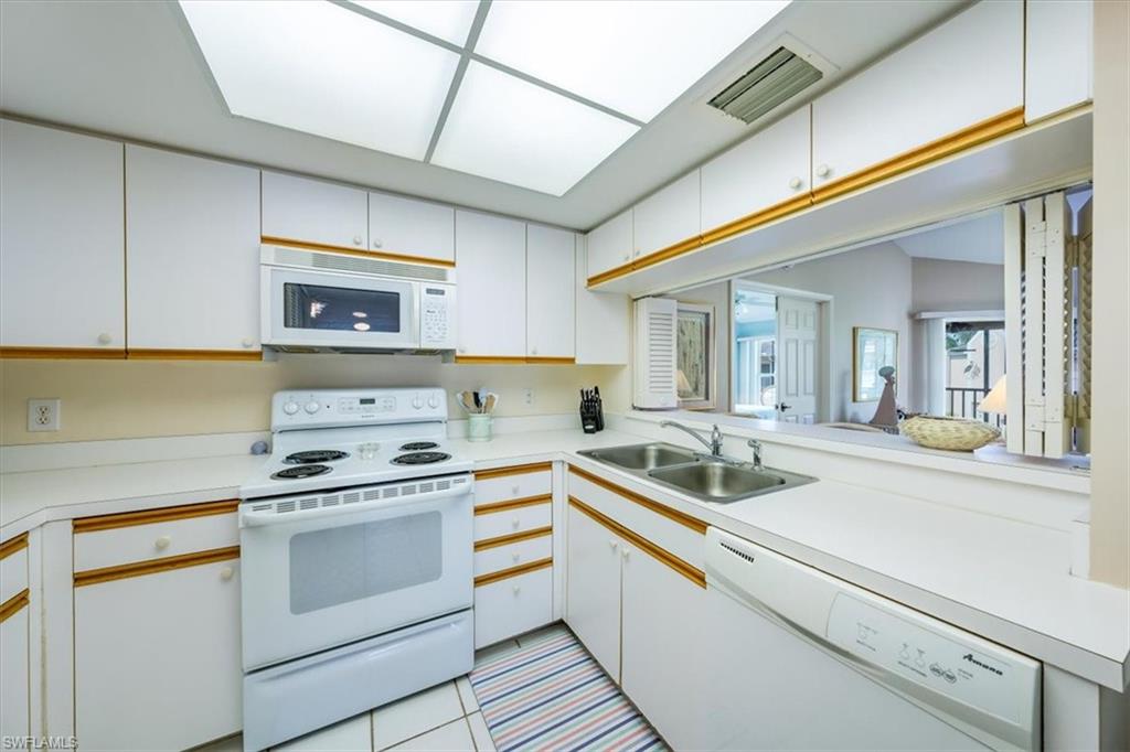 5637 Turtle Bay Drive, Unit 16 Naples, FL 34108 - Photo 7 of 22 a kitchen with a stove and a sink