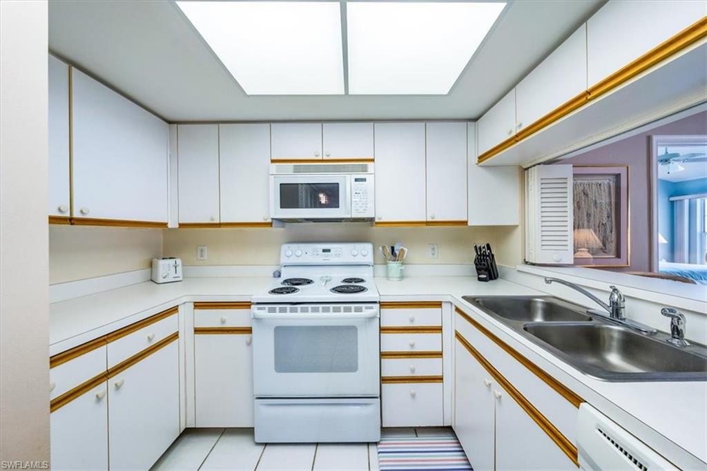 5637 Turtle Bay Drive, Unit 16 Naples, FL 34108 - Photo 8 of 22 a kitchen with a sink stove top oven and cabinets