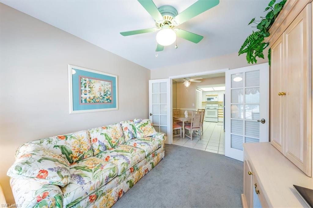 5637 Turtle Bay Drive, Unit 16 Naples, FL 34108 - Photo 10 of 22 a bedroom with a bed and a chandelier