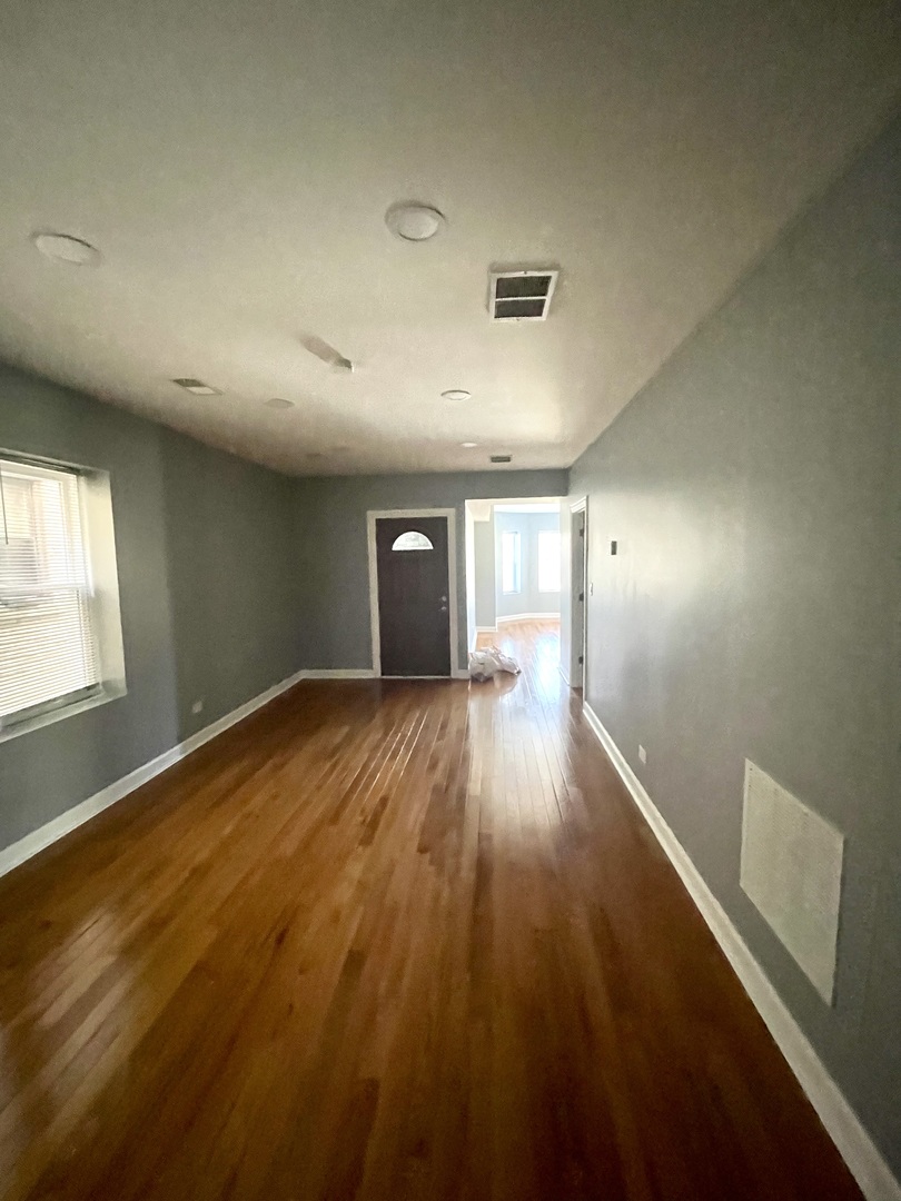 4969 North Kilpatrick Avenue, Unit 1 Chicago, IL 60630 - Photo 5 of 6 an empty room with wooden floor and windows