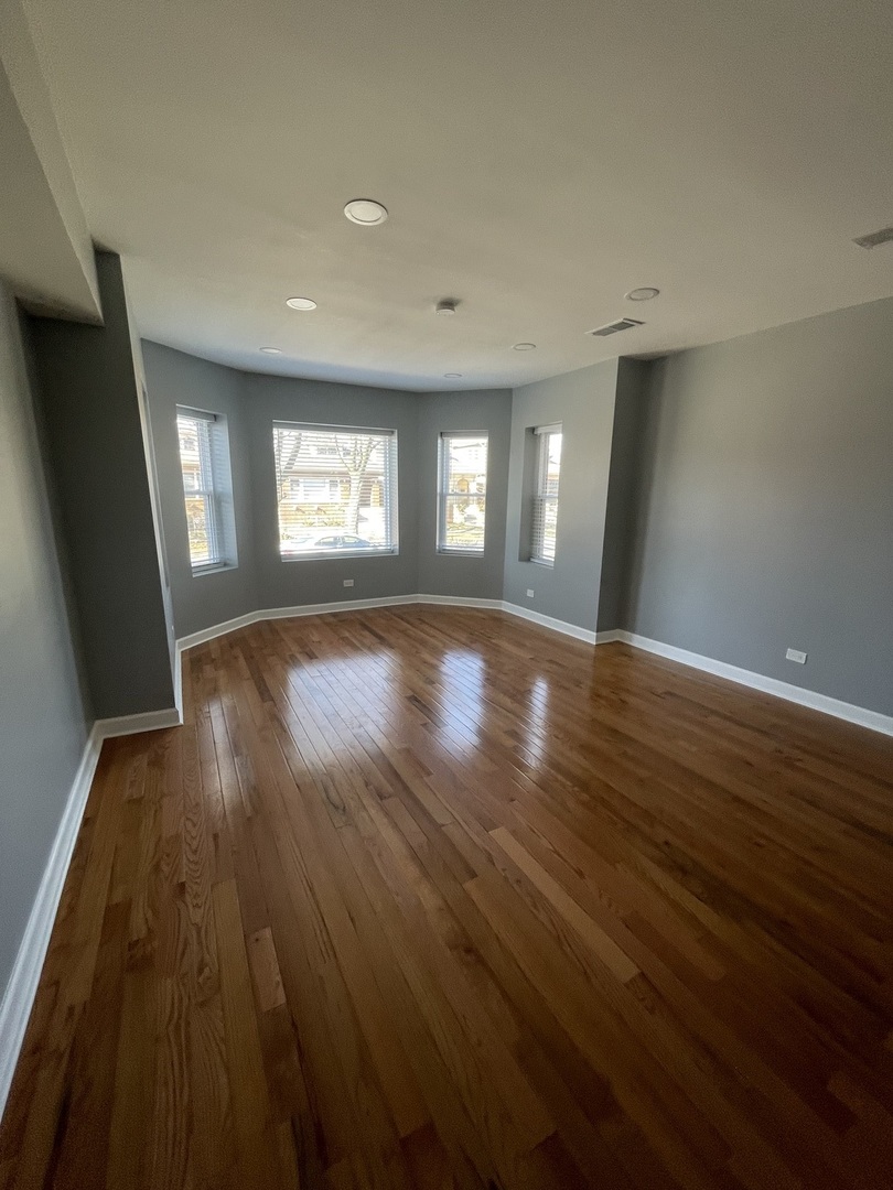 4969 North Kilpatrick Avenue, Unit 1 Chicago, IL 60630 - Photo 6 of 6 an empty room with wooden floor and windows