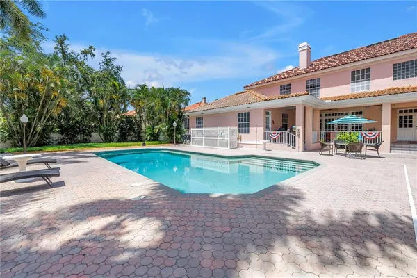 a view of a white building with a swimming pool and sitting area