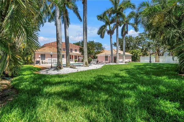 a view of a building with a big yard and palm trees