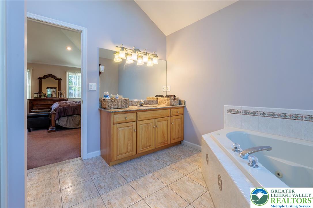 2170 Clearview Road Coplay, PA 18037 - Photo 39 of 75 This serene bathroom offers a spa-like retreat with a jetted tub and vanity leading to a peaceful bedroom.
