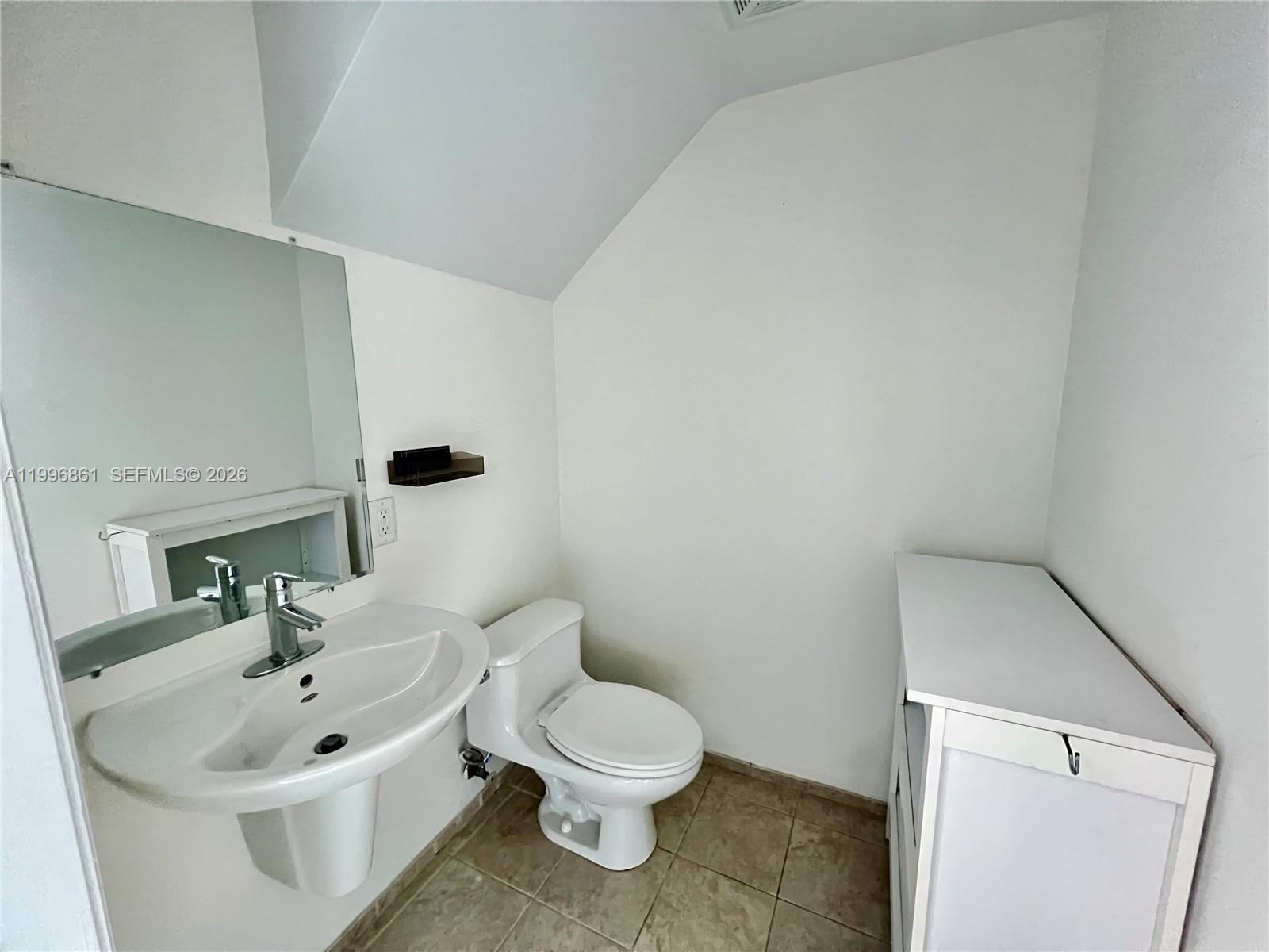 60 Southwest 13th Street, Unit 1611 Miami, FL 33130 - Photo 11 of 28 a bathroom with a sink a toilet and a mirror