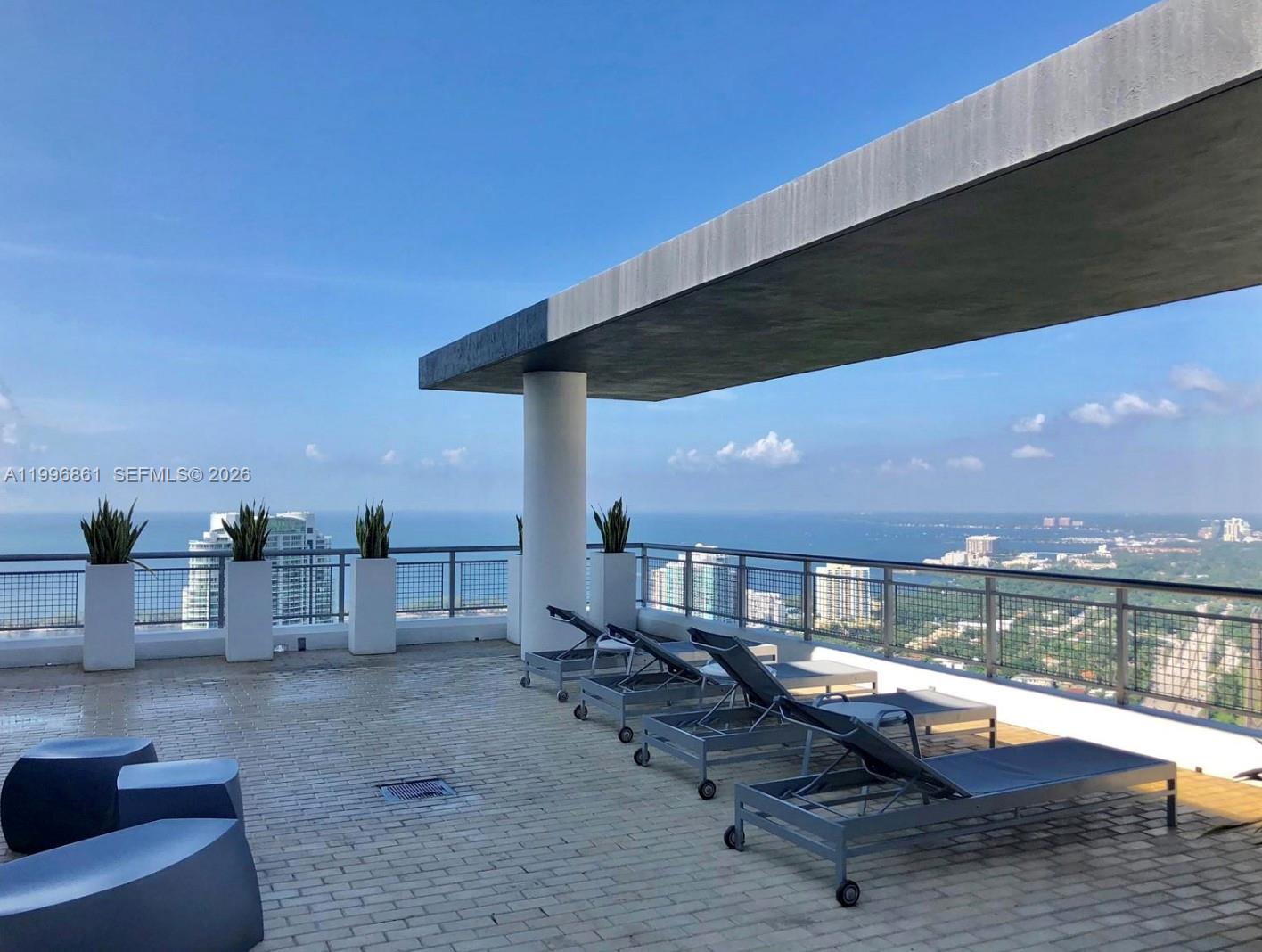 60 Southwest 13th Street, Unit 1611 Miami, FL 33130 - Photo 16 of 28 a roof deck with table and chairs