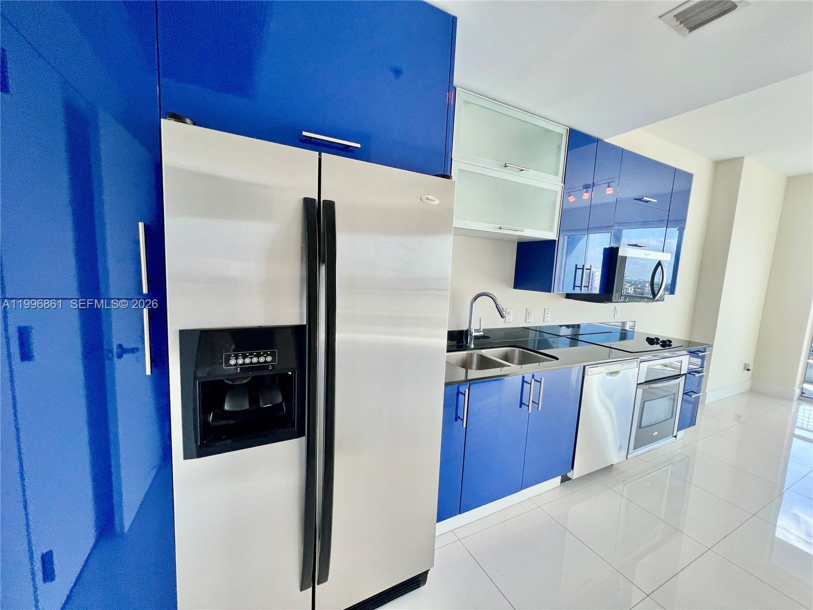 60 Southwest 13th Street, Unit 1611 Miami, FL 33130 - Photo 5 of 28 a kitchen with stainless steel appliances granite countertop a refrigerator and a stove