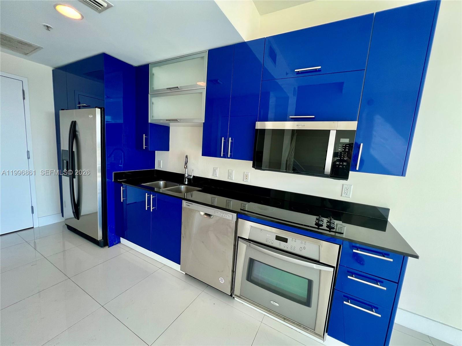 60 Southwest 13th Street, Unit 1611 Miami, FL 33130 - Photo 6 of 28 a kitchen with stainless steel appliances a microwave a stove and a refrigerator