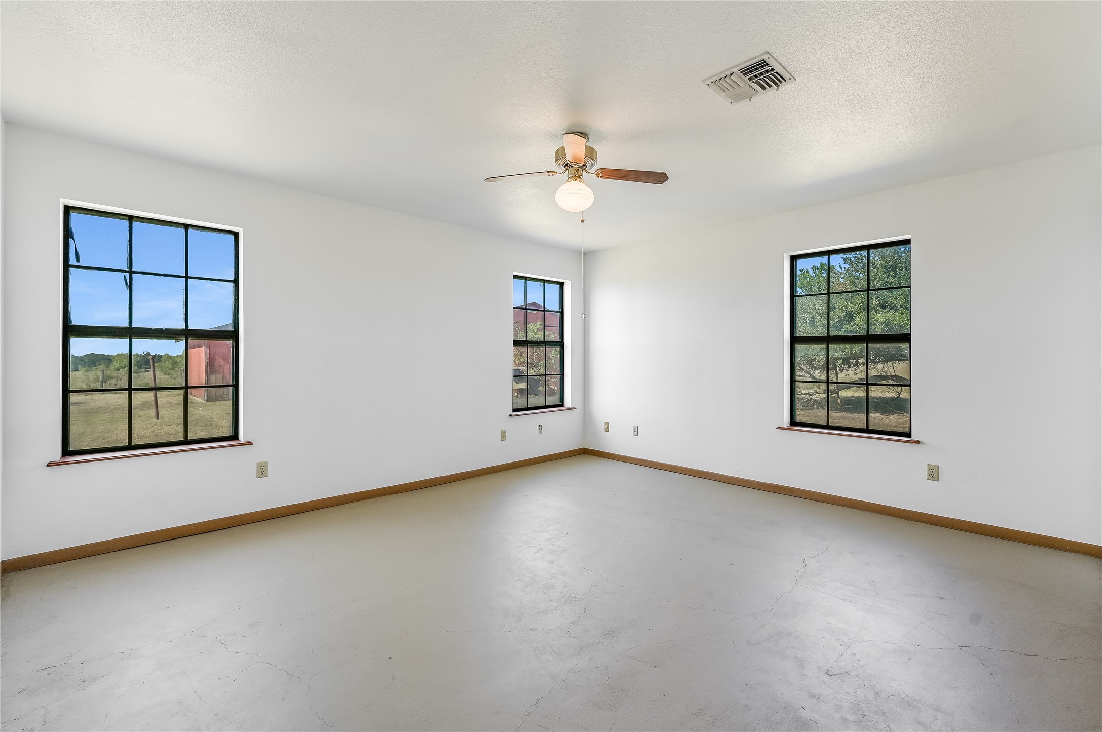 5637 Jeddo Road Waelder, TX 78959 - Photo 15 of 37 an empty room with windows and ceiling fan