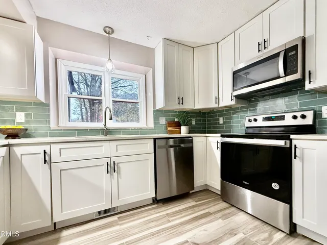 a kitchen with stainless steel appliances granite countertop a stove microwave and sink