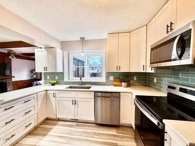 a kitchen with a sink stove and microwave
