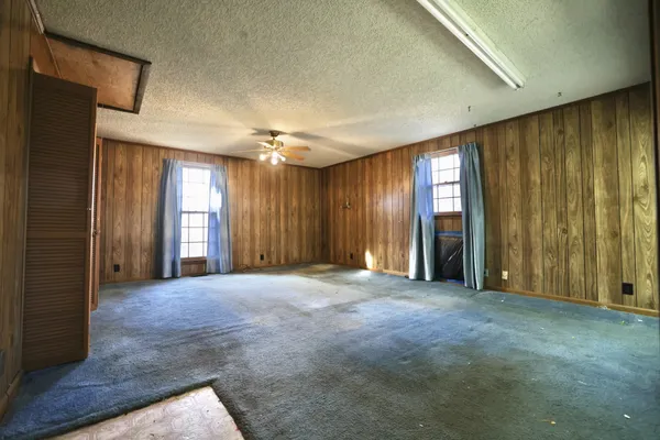 a view of empty room with a fireplace and fan