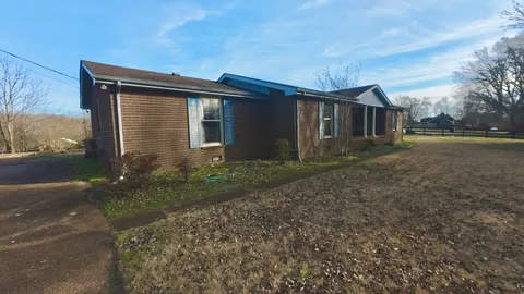 a front view of house with yard and trees