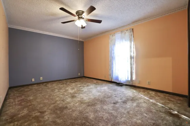 an empty room with closet and fan