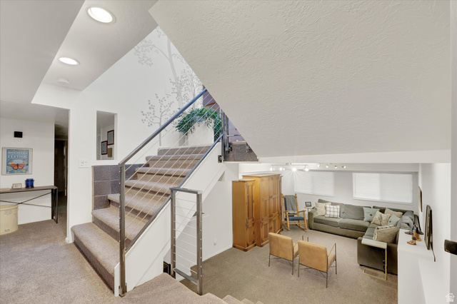 510 Spring Creek Road Providence, UT 84332 - Photo 31 of 97 Multi-level interior featuring carpeted stairs with cable railings, recessed lighting, and a lower-level living area with windows
