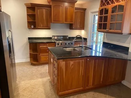 a kitchen with stainless steel appliances granite countertop a refrigerator a microwave and cabinets