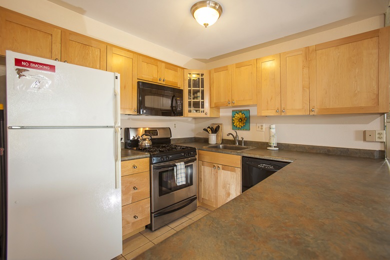 2531 South Kihei Road, Unit C512 Kihei, HI 96753 - Photo 15 of 27 a kitchen with stainless steel appliances granite countertop a stove a sink dishwasher a refrigerator and a microwave