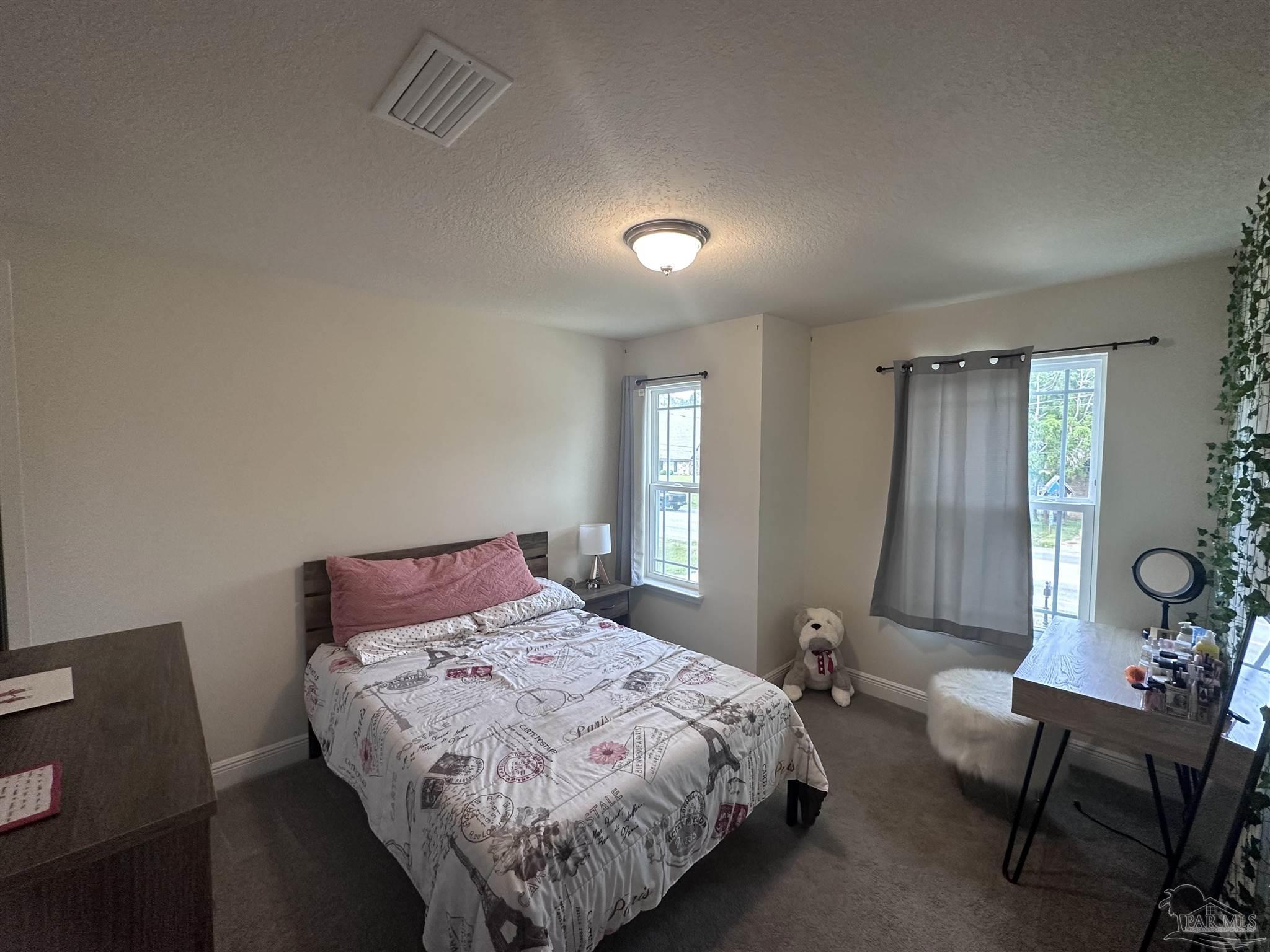 5217 Saufley Field Road Pensacola, FL 32526 - Photo 15 of 26 a bedroom with a bed and a chair