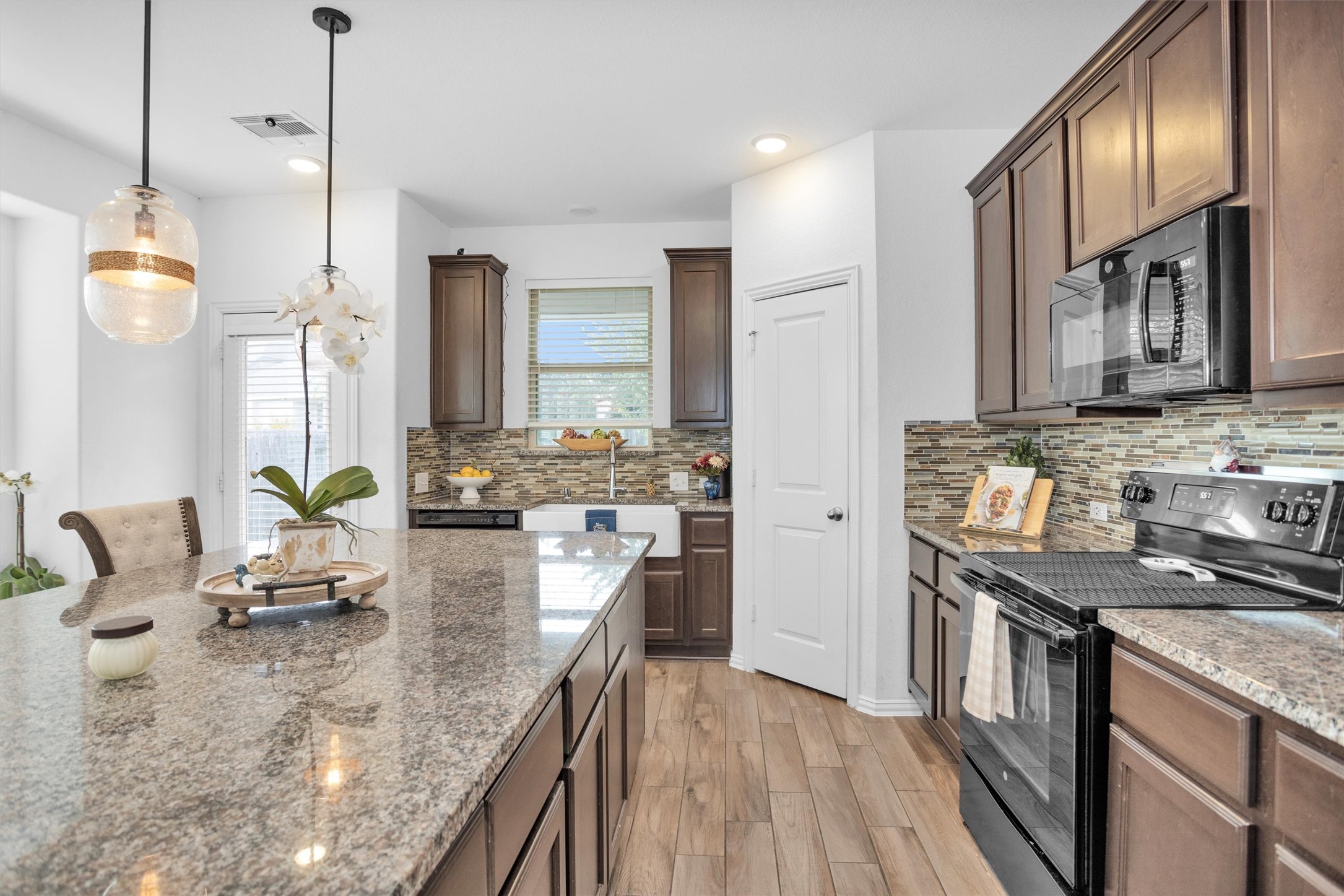 118 Emory Birch Montgomery, TX 77316 - Photo 11 of 35 a kitchen with stainless steel appliances granite countertop a stove a sink and a refrigerator