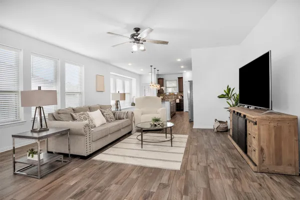 a kitchen with stainless steel appliances a dining table chairs stove and refrigerator
